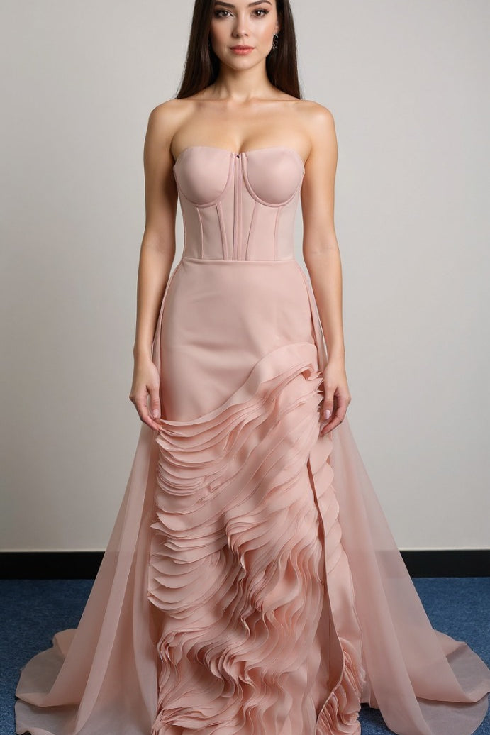 This exquisite strapless gown in a delicate dusty rose hue exudes modern romance. It features a beautifully structured corset bodice with sheer paneling for a touch of allure. 